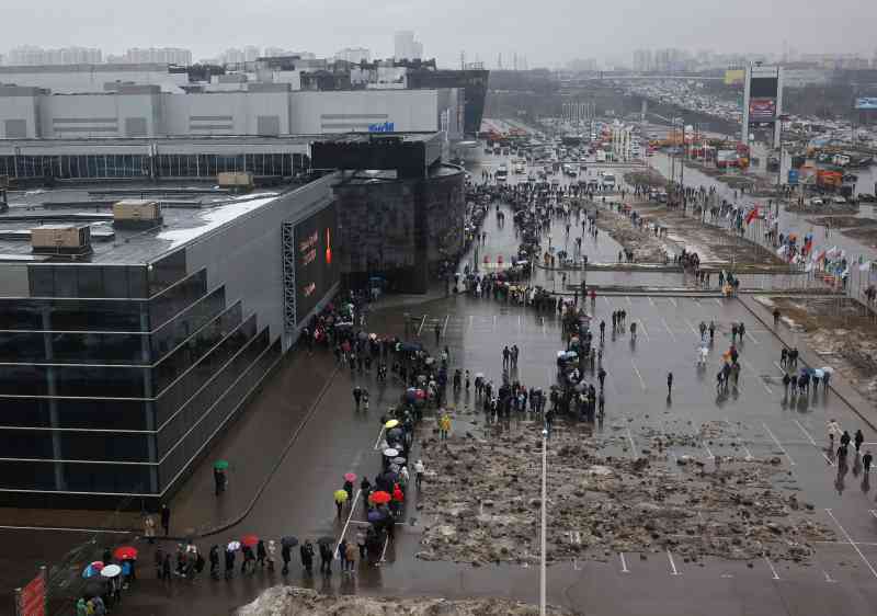 Personas haciendo fila afuera del Crocus City Hall para rendir homenaje floral a las víctimas del ataque terrorista